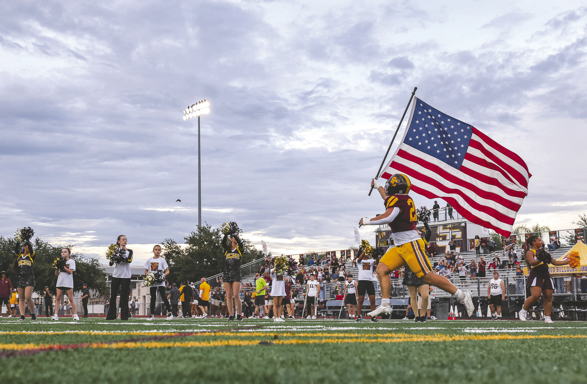 Ahead of the Bulldogs’ football game against Lake Minneola. Junior linebacker J.T. Wrona led the team on the field with the Stars and Stripes, something also done at a number of other Week 4 games Friday. (Photo/Taylor McFee)