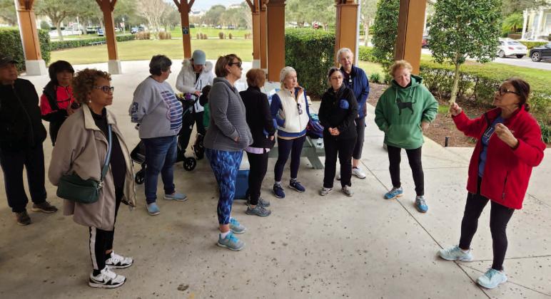 About two dozen people came out for the first “Walk With a Doc,” and took a mile stroll with longtime VA nurse practitioner Lydia Rivera (in red jacket). PHOTO/KEN JACKSON