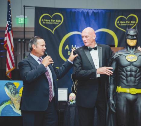 County Commissioner and resident auctioneer Ricky Booth assists John Kalish with the live auction.