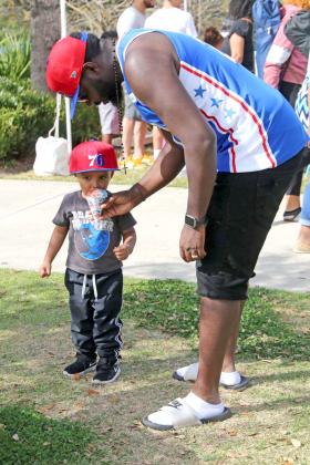NEWS-GAZETTE PHOTO/NANCY BRIGHAM   Jaiden, 3, of St. Cloud, is treated to a sno-cone with the help of his father, Marcus.