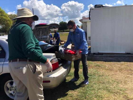 Osceola County Commissioner Brandon Arrington loading food into a truck of a car.