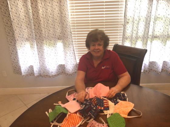 DAR Daughter Ginny Brown sits with the numerous masks she has sewn for medical field employees.