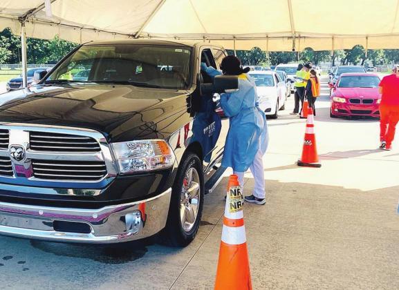 A motorist gets tested for COVID-19 at Osceola Heritage Park testing site.