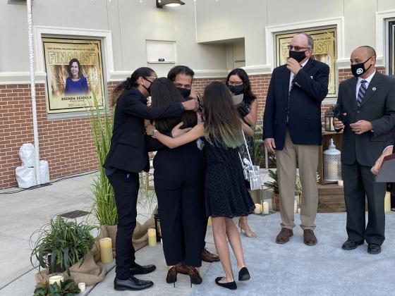 Alvin Olivo is hugged by his family after winning teacher of the year.