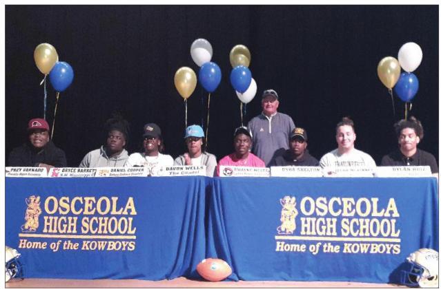 Osceola Head Coach Doug Nichols (back row) is with his eight seniors who signed scholarship offers on National Letter of Intent Day in 2020. .