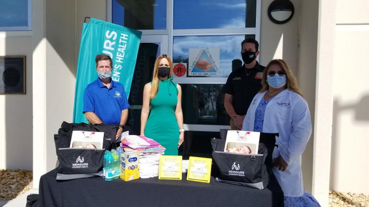 County fire leaders and those from Nemours Hospital and A Safe Haven For Newborns show some of the hospital's donations made to the program. PHOTO/KEN JACKSON