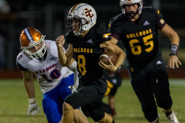 St. Cloud's Julian Nasco picks up yards as Harmony's Josh Moss closes in during the Bulldogs' 31-30 victory Friday in the Soldier City Classic. PHOTO/ROB HERBERT