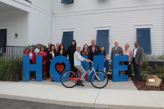 County Commissioner Cheryl Grieb looks to ride up to OSCAR’s new bike rack, the concept of Zenith Accelerated Learning Academy student Andrew Haskins (to her left). PHOTO/KEN JACKSON