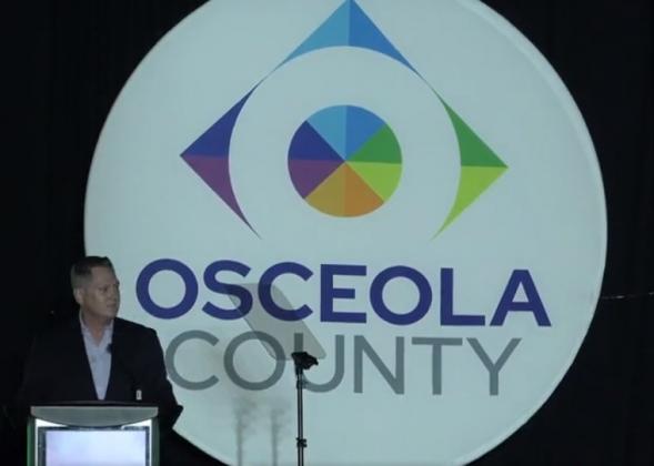 Brandon Arrington shows off the county’s new “What’s Next” logo at Wednesday’s State of the County address at Osceola Heritage Park. PHOTO/OSCEOLA COUNTY