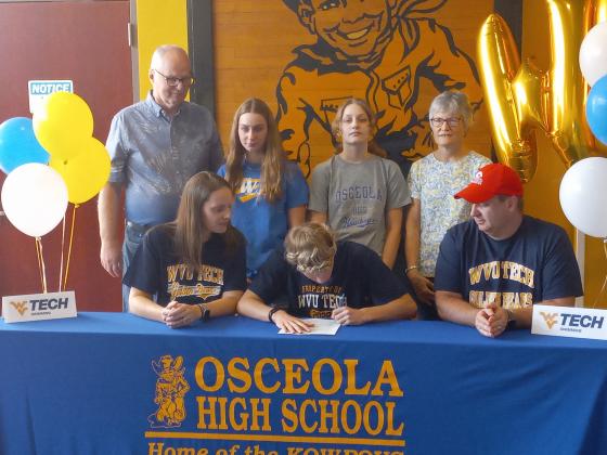 :  Surrounded by his family, Osceola swimmer Noah Maniace signs his athletic scholarship papers to West Virginia Tech on Friday. PHOTO/J. DANIEL PEARSON.