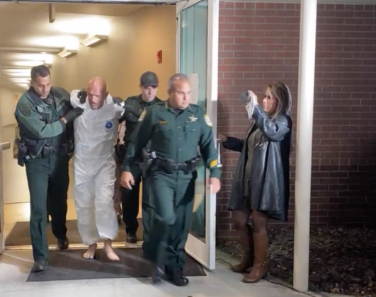 Sheriff's deputies escort rape suspect Osvaldo Figueroa to a cruiser to take him to the Osceola County Jail. PHOTO/SHERIFF'S OFFICE