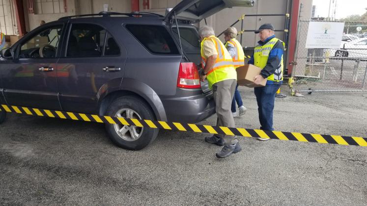 Shortly after Thursday’s ribbon cutting, the food-needy of the community arrived at the Osceola Council on Aging St. Cloud site to pick up food staples. PHOTO/KEN JACKSON