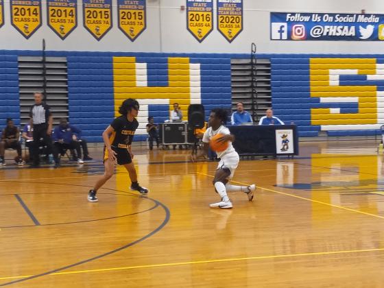 Osceola guard Chris Combs (white jersey) brings the ball up court on Ft. Pierce’s Joshua Banate. Combs spurred a fourth quarter rally by scoring 11 of his 17 points in leading Osceola to a 67-51 win. PHOTO/DAN PEARSON