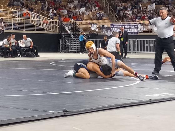 Osceola High’s Cooper Haase (white) works a move Nikolas Hernandez during the FHSAA Class 3A State Championship Wrestling Finals.  Haase eventually pinned Hernandez to win his third state title. PHOTO/J. DANIEL PEARSON