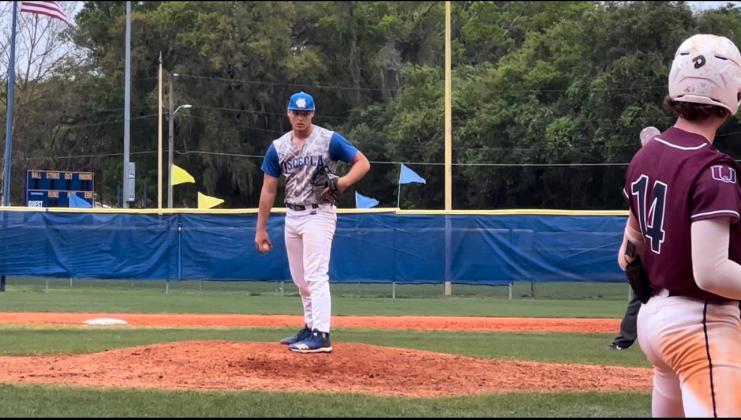 Palm Harbor’s Sam Mummau (14) prepares to step into the batter’s box against Osceola pitcher Chris Palmi.  The Kowboys earned a split in the doubleheader as Palmi worked five innings of three-hit ball in the 2-1 win.   (Photo Courtesy Carrie Palmi)