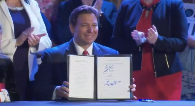 Gov. Ron DeSantis signs House Bill 5, which makes abortions after 15 weeks of pregnancy illegal, at an event Thursday at Nacion de Fe Church in Kissimmee. SUBMITTED PHOTO