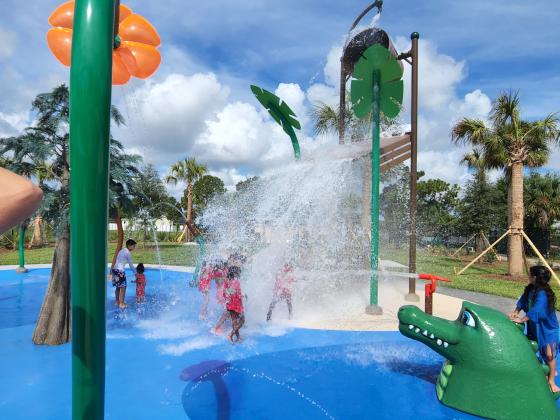 Children from the Boys &amp; Girls Club of Buenaventura Lakes enjoy the el Yunque Rainforest Splash Pad -- especially the big bucket that rains down a waterfall every 45 seconds or so -- at its grand opening Monday PHOTO/KEN JACKSON