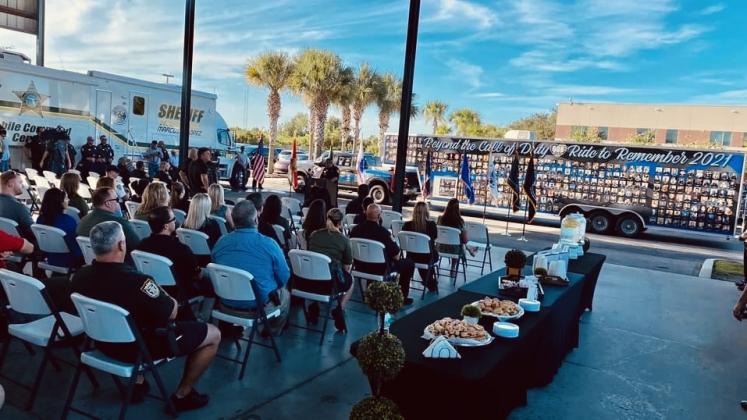 Members of Beyond the Call of Duty gather to show their respects to those fallen, including Osceola Deputy Michael Riley Webb, on the tribute trailer. PHOTO/CHRIS MILLER