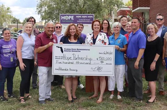 Elected officials, such as state Sen. Victor Torres, Rep. Kristen Arrington, U.S. Rep. Darren Soto Osceola County Commissioner Cheryl Grieb were on hand Thursday to present Hope Partnership CEO Rev. Mary Downey with funding to purchase and build affordable housing. PHOTO/HOPE PARTNERSHIP