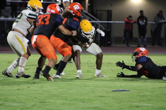 Tohopekaliga 's Elias Fernandez (52) and Juan Gonzalez (33) wrap up Liberty quarterback Jeremiah Pierre-Louis in the Tigers' 49-0 win Friday. PHOTO/LINDSEY TELLEZ