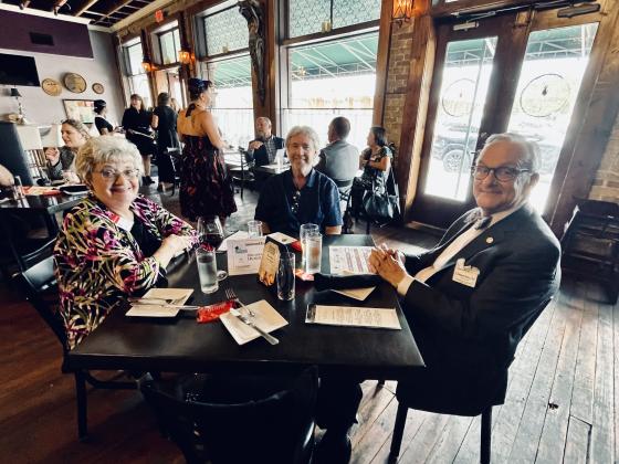St. Cloud Chamber of Commerce President Dirk Webb (center) enjoying a fine meal.