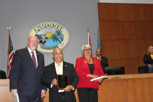 Kissimmee City Manager Mike Steigerwald and Mayor Olga Gonzalez offer outgoing Commissioner Felix Ortiz (center) a token of appreciation. PHOTO/KEN JACKSON