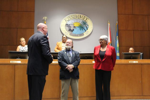 Kissimmee City Manager Mike Steigerwald and Mayor Olga Gonzalez offer outgoing Commissioner Jim Fisher (center) a token of appreciation.  PHOTO/KEN JACKSON