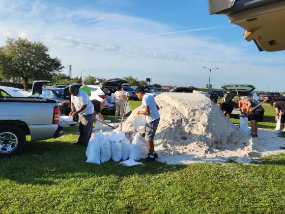 Residents work to fill sandbags Monday morning at Osceola Heritage Park ahead of Hurricane Ian. The area could receive 4-8 inches of rain. PHOTO/KEN JACKSON