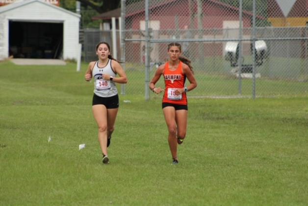Harmony's Leilana Decker (left) races with defending champion Catalina Edwards midway through the girls OBC cross country race. PHOTO/LINDSEY TELLEZ