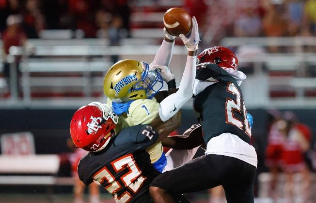 Osceola receiver T.J. Massey goes up for a catch between Vero Beach defenders in Friday night's win. PHOTO/REINHOLD MATAY