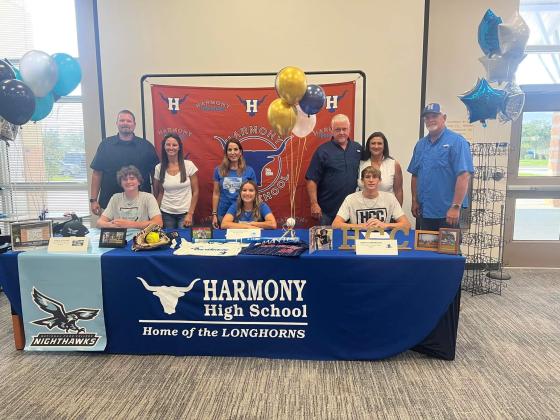 Harmony High's Trace Loeding, Kaitlyn Luna-Rodriguez and Caden Scarborough sign college scholarships Wednesday.