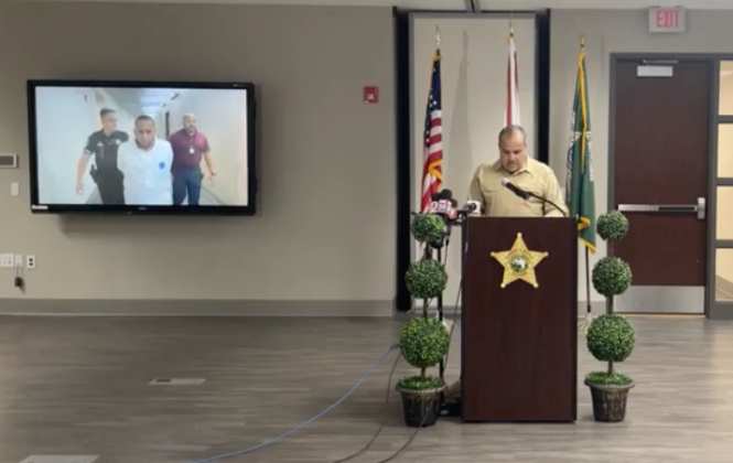 A video of murder suspect Carlos Luis Lopez-Bayona being led to the Osceola County Jail plays while Sheriff Marcos Lopez gives details of his and four other co-conspirator’s arrest Wednesday. PHOTO VIA SHERIFF’S OFFICE VIDEO