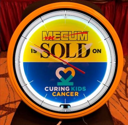 A  “Mecum SOLD” wall clock for Curing Kids Cancer (CKC) is being sold each day at the Mecum Kissimmee car auction. PHOTO/MECUM