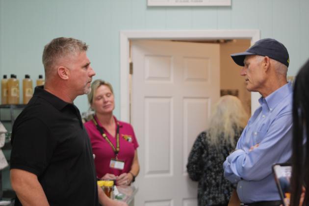Rick Scott talks with the operators of 3 Beez Honey Farm on New York Avenue Wednesday. PHOTO/KEN JACKSON