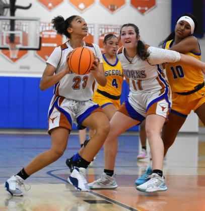 Harmony's Ellah Husbands drives to the basket while Emerson Aslan sets a screen in Friday's 43-37 District 7A-5 championship game win over Osceola. PHOTO/KATIE WILLIAMS