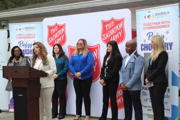 Kissimmee’s Liz Canet (at podium) and Amanda Wilkerson (far left) became the first clients of Pathway to Housing, a Salvation Army of Orange and Osceola County program aimed at stopping the cycle of renting for working-class families.