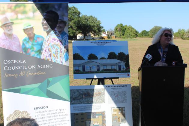 Osceola Council on Aging CEO Wendy Ford shows off renderings of what the 60 Buen Vecino housing units will look like at Tuesday's event. PHOTO/KEN JACKSON