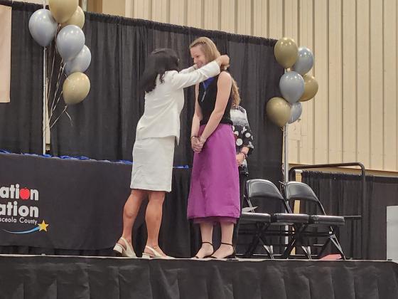 Osceola County School Superintendent Dr. Debra Pace awards a scholarship in her name to county scholar Libby Thornton at Wednesday’s Education Foundation Scholarship Awards ceremony. PHOTO/KEN JACKSON