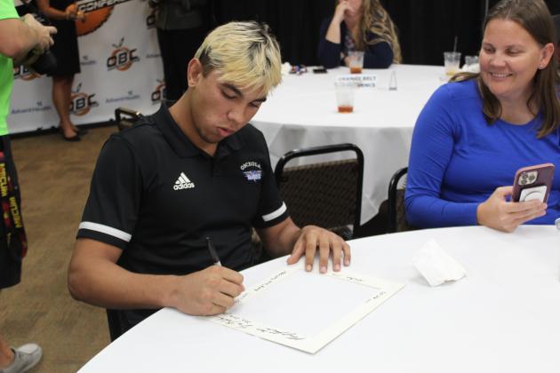 Male Athlete of the Year Cooper Haase signs his frame as mom Shanel Davidson-Haase looks on. PHOTO/KEN JACKSON