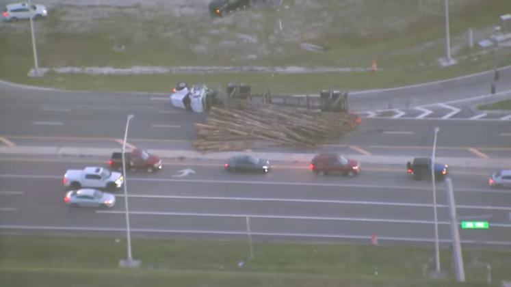 An overturned logging truck at Nova Road has the westbound lanes of 192 closed, although traffic is able to get through cutting through the BP gas station at the corner. PHOTO/CLICKORLANDO.COM
