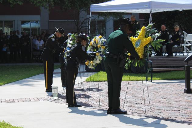 Officers from Osceola County's four law enforcement agencies place wreaths to honor their fallen fellow officers at Thursday's Law Enforcement Memorial. PHOTO/TERRY LLOYD