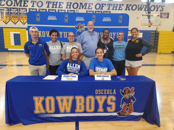 Wrestler Cathia Timas (left, Allen University) and volleyball player Ahnika Johnston (St. Petersburg College) signed at Osceola High School Wednesday. PHOTO/KEN JACKSON