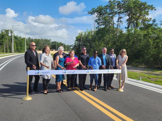 Osceola County and construction officials cut the ribbon to open the new northern 1.13 miles of Bill Beck Boulevard to Osceola Parkway. PHOTO/KEN JACKSON