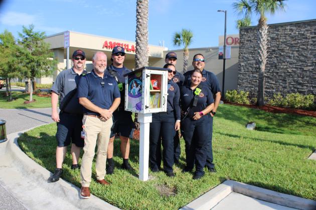 Orlando Health St. Cloud Hospital President Brian Wetzel with city Fire/EMS staff and Friday's unveiling of the newest St. Cloud FirePALS Community Book Box. PHOTO/TERRY LLOYD