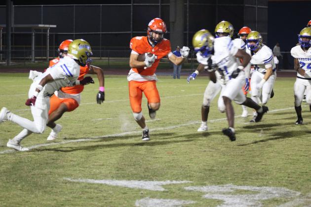Tohopekaliga's Julian Nasco runs for yardage while the Osceola defense closes in. PHOTO/KEN JACKSON