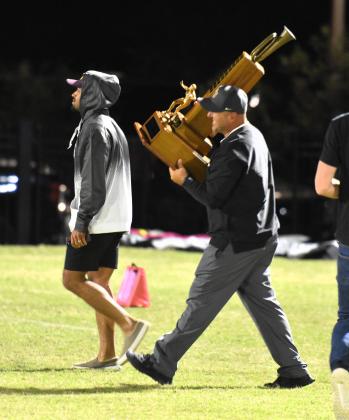 St. Cloud's Mike Short hoists the Brass Bugle trophy for the first time, to take to his team Friday. PHOTO/KATIE WILLIAMS