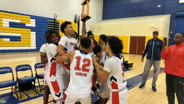 Poinciana players hold the Kowboy Invitational Trophy aloft after defeating Chattahoochie (Georgia), 63-60 in overtime Thursday night. PHOTO/J. DANIEL PEARSON