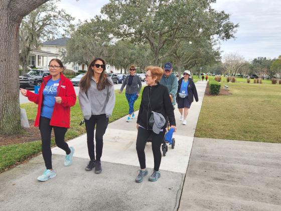 About two dozen people came out for the first “Walk With a Doc,” and took a mile stroll with longtime VA nurse practitioner Lydia Rivera (in red jacket). PHOTO/KEN JACKSON