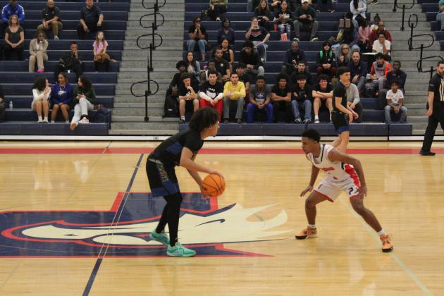 Poinciana's Elijah Davis defends Osceola's Luke McCrimon (left with ball) during the Eagles' 56-42 OBC boys basketball tournament semifinal Wednesday. PHOTO/KEN JACKSON