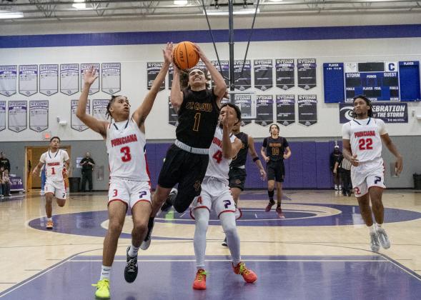 St. Cloud guard Diomar Ortiz drives to the basket through the defense of Poinciana's Jordan Isaac (3) and Steven Bennett (4) in Friday's Orange Belt Conference championship game. PHOTO/MARIO CASAMALHUAPA